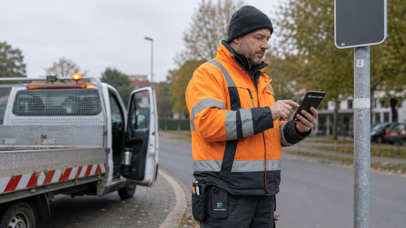 Bauhof-Mitarbeiter dokumentiert eine Verkehrssicherungskontrolle mit dem Smartphone im öffentlichen Raum